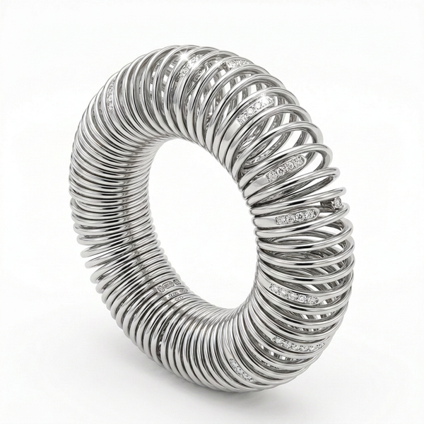 A silver-toned spiral bangle bracelet with pavé diamonds set along the outer bands, photographed on a clean white background.