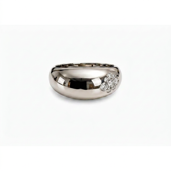 A polished silver band ring featuring a small cluster of diamonds on one side, set against a plain white background.