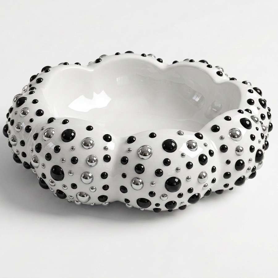 A white resin bowl with a scalloped rim, decorated with black and silver rhinestone-like studs, shown on a light gray background.