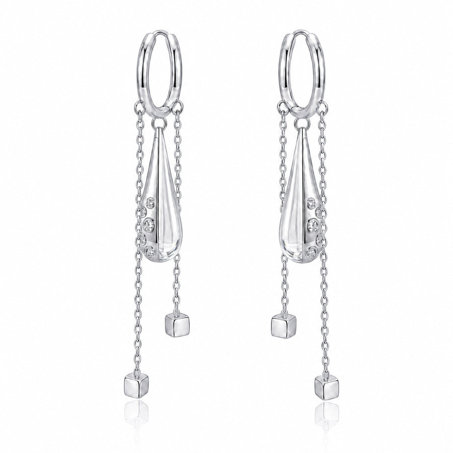 A pair of silver drop earrings with a circular hoop, a teardrop-shaped pendant, delicate chains, and small dangling cube charms on a white background.
